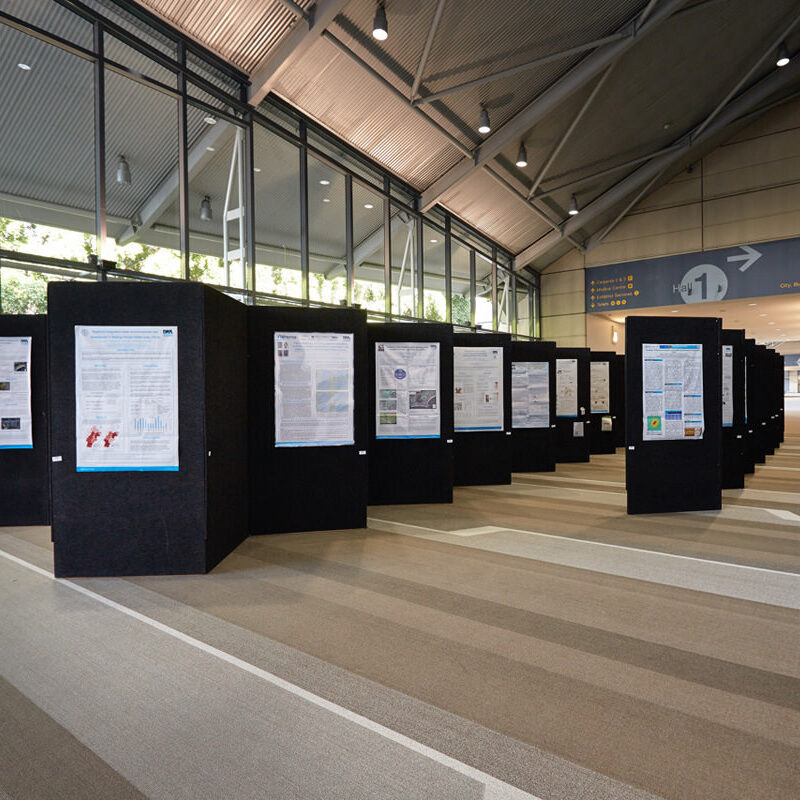 A spacious area showcases multiple Vertical Display Panels on Castors featuring scientific posters in a well-lit, modern ambiance.